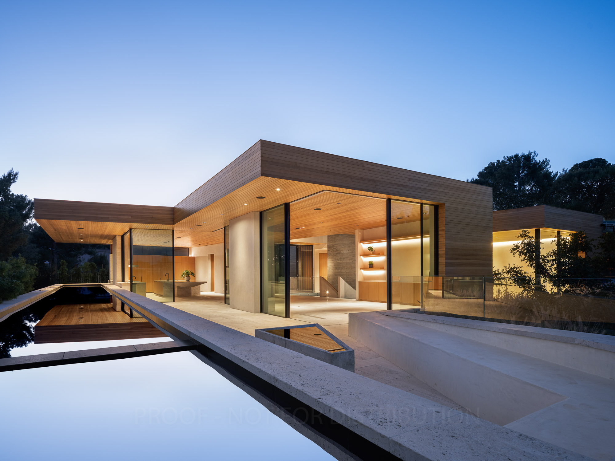 Modern luxury residence with floor-to-ceiling Styline glass walls, wood ceiling, and infinity pool at twilight