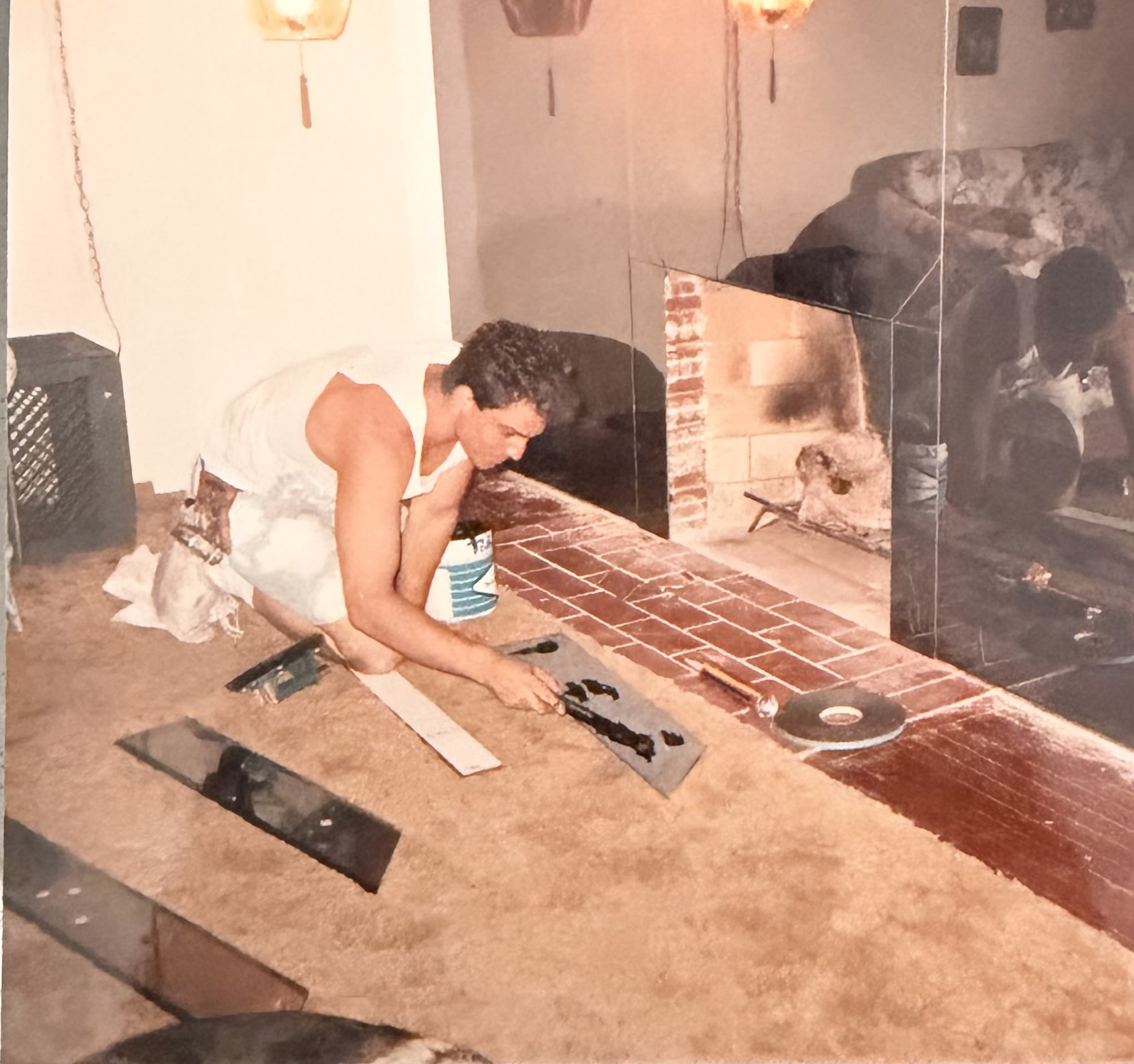 Samuel Ward cutting mirror and glass during an early residential installation
