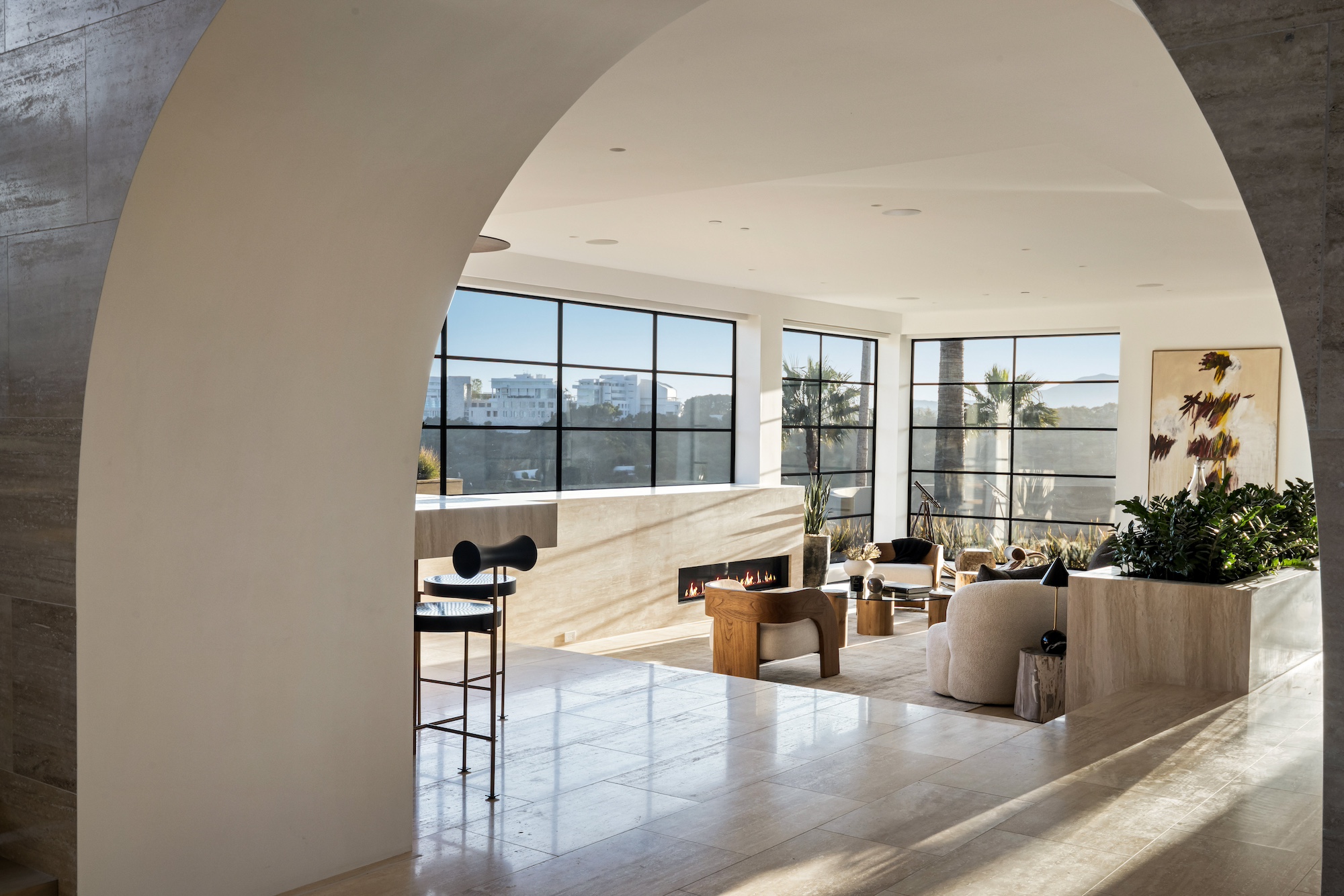 Contemporary living space with arched entry and Steel Essence™ steel-look window wall with fireplace